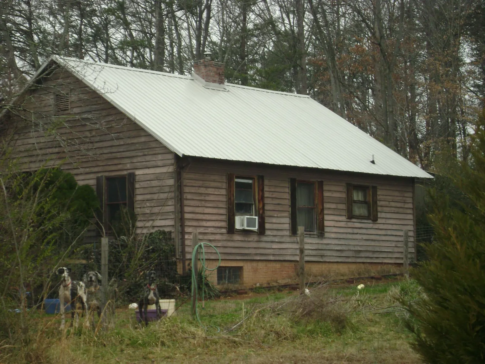 White metal roof on an old wood sided farmhouse, from a Metal Roof Installation job in Seffner